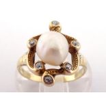 A baroque pearl (untested) and diamond ring, the central pearl 8.2 x 7.4mm, in a punched scroll