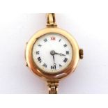 A 1920s lady's 9 carat gold manual wind wrist watch, the white enamel dial with black Roman