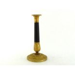 A French Empire parcel gilt bronze candlestick, the dark bronze ribbed column with gilt classical