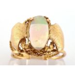 An opal ring, the oval precious opal cabochon 12.4 x 6.1mm, to trifurcated shoulders, mounted in