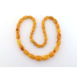 A butterscotch amber necklace, composed of graduated barrel shaped beads, 448cm long, 30.3gms