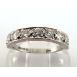 An 18 carat white gold and diamond half hoop diamond ring, set with nine uniform brilliants,