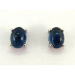 A pair of sapphire ear studs, each stud claw set with a single oval cabochon 7.1 x 5.2mm, mounted in