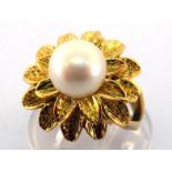 A yellow metal (tests 18 carat gold) and cultured pearl ring, the single 9mm pearl surmounting a two