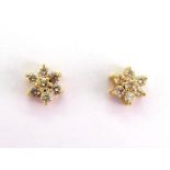 A pair of diamond daisy cluster ear studs, each stud composed of seven brilliants totalling