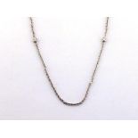 A platinum and diamond necklace, the fine chain set along its length with two spectacle set