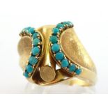 A yellow metal (tests 18 carat gold) and turquoise dress ring, the cross over bezel of abstract