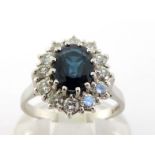 A sapphire and diamond cluster ring,the central oval cut stone 7 x 6 x 2.8mm, in a surround of