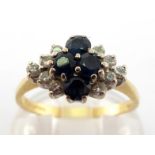 An 18 carat gold, sapphire and diamond cluster ring, composed of a central quatrefoil of round cut