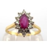 An 18 carat gold, ruby and diamond cluster ring, the marquise cut ruby 7 x 3.7mm, in a surround of