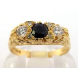 An 18 carat gold, sapphire and diamond three stone ring, the central round cut sapphire 3.8mm