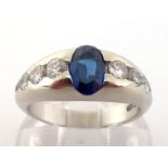 A sapphire and diamond ring, the central oval cut sapphire approx. 1 carat, rub over set, to