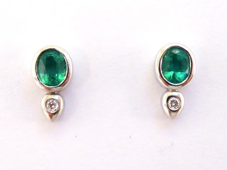 A pair of emerald and diamond ear studs, each stud set with an oval cut emerald, a small rub over