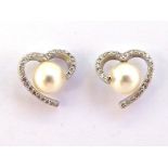 A pair of cultured pearl and diamond ear studs, the 7mm central round pearls in a heart shaped