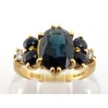 An 18 carat gold, sapphire and diamond ring, the central oval cut sapphire 9 x 6.8 x 4.3mm, to