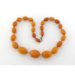 A butterscotch amber bead necklace, composed of graduated oval beads, 41cm long, 27.8gms