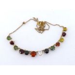 A multi gem necklace, composed of graduated round cut almandine and hessonite garnets, zircon, and