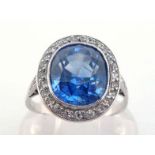 A sapphire and diamond cluster ring, the central oval cut stone 10 x 8 x 6.2, in a surround of