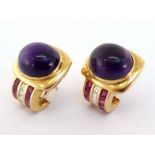 A pair of amethyst, diamond and ruby ear clips, the top set with an oval cabochon amethyst 13.8 x