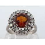 A citrine and diamond cluster ring, the central round mixed cut citrine 8.1 x 6.2mm, in a surround