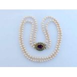 A two strand cultured pearl necklace, composed of uniform approx. 7.2mm off round pearls, to an