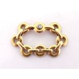 Cartier, a gold ring, composed of articulated links, one rub over set with a small brilliant, finger