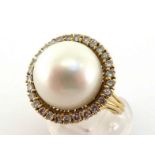 A South Sea cultured pearl and diamond ring,the central round pearl 14.5mm, in a surround of small