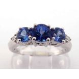 A 14 carat white gold, tanzanite and diamond ring, set with three graduated central round cut