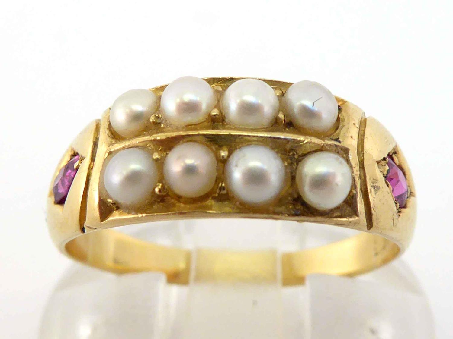 A late Victorian 18 carat gold split pearl and ruby ring, set to the centre with two rows of 2.