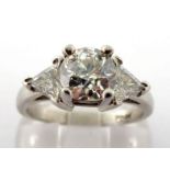 A diamond dress ring, the central old cut brilliant approx. 1.35 carat, claw set above trillion