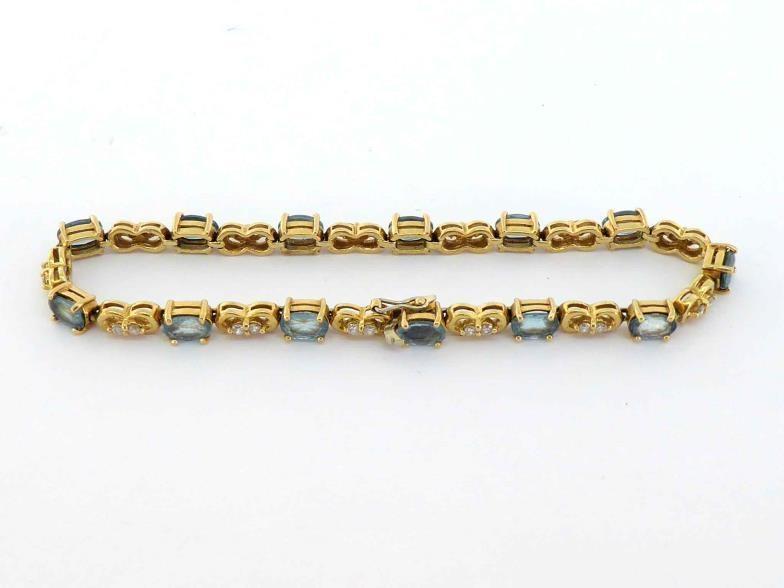 An aquamarine and diamond line bracelet, composed of alternate oval cut aquamarines and pairs of