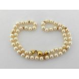 An Italian 18 carat gold and cultured pearl princess length necklace, composed of uniform 6.8mm