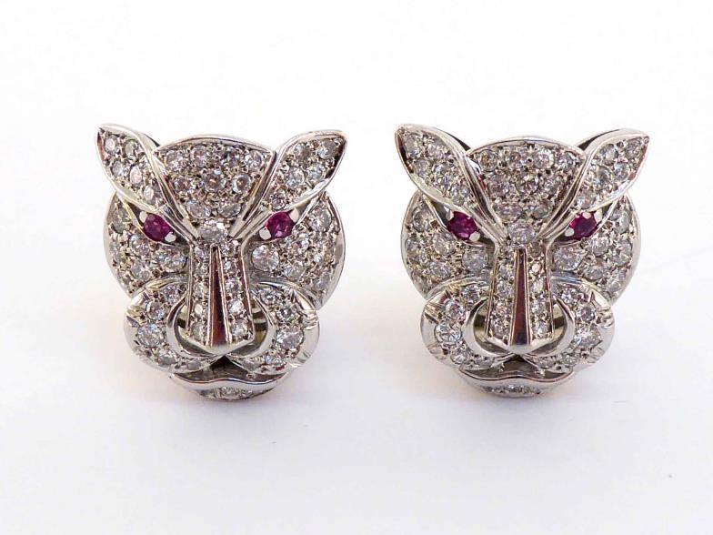 A pair of diamond and ruby ear clips, designed as panther heads, pave set overall with ruby set