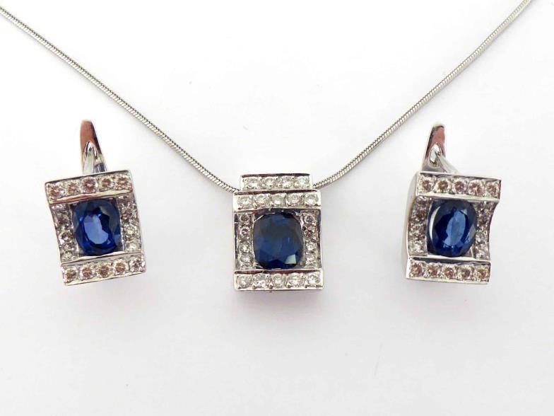 A sapphire and diamond pendant and earring suite, the pendant with a central oval cut stone, in a