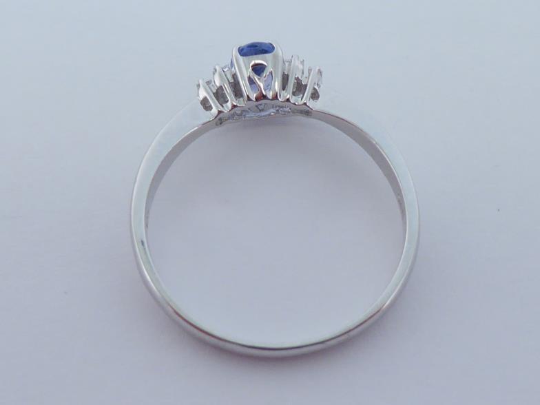 A tanzanite and diamond ring, the central oval cut tanzanite 6 x 4mm, between two pairs of graduated - Image 2 of 4