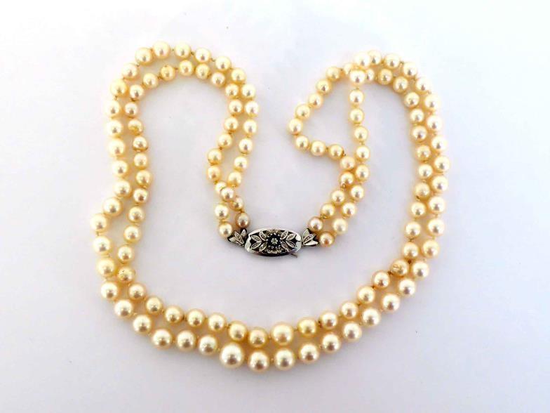 A two strand matinee length cultured pearl necklace, composed of graduated 9.4 x 6.2mm, to an 18