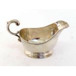 A silver sauceboat by Adie Brothers Ltd., Birmingham, 1946, oval on spreading foot, reeded rim