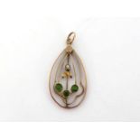 An early 20th century demantoid garnet and seed pearl pendant, the open work ovoid drop 3cm long,