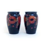 A pair of Moorcroft vases in the Pomegranate pattern on a dark blue ground, circa 1925, the bases