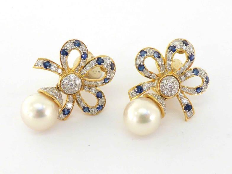 A pair of diamond, sapphire and cultured pearl ear clips, the bow top pave set with small brilliants