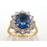 A 18 carat gold, sapphire and diamond cluster ring, the central oval cut stone 9.9 x 8 x 4.4mm, in a