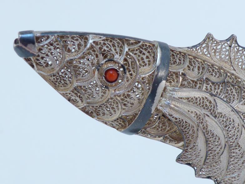 A silver filigree ornament of a leaping salmon, with red glass eyes, on shell-shaped base, - Image 2 of 2