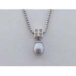 A cultured pearl and diamond pendant, the ovoid pearl 8.5 x 7.3mm, the box bale set with four