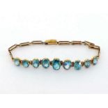 A 1940s gold and blue zircon line bracelet, composed of nine graduated oval cut stones (one replaced