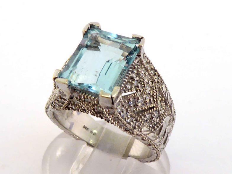 An aquamarine and diamond dress ring, the central emerald cut stone 11 x 9 x 6.2mm (approx. 4.07