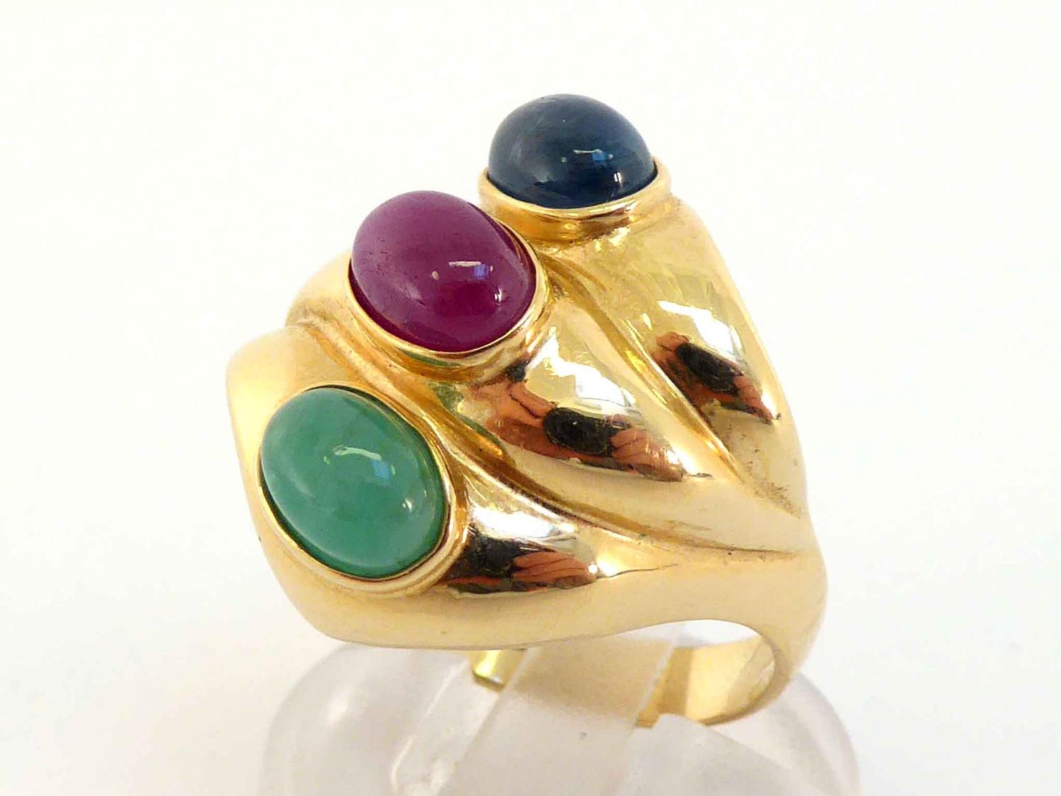 A ruby, sapphire and emerald dress ring, set obliquely with three oval cabochons, each 7.1mm long,