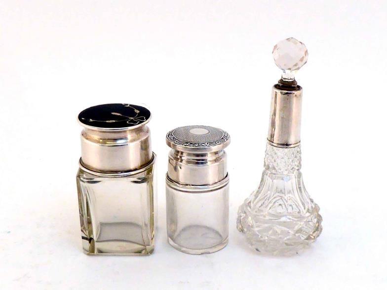 A silver-mounted glass smelling salts bottle with tortoiseshell top to cover inlaid with silver