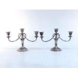 A pair of Iranian white metal (tests silver) three-light dwarf candelabra chased with geometric
