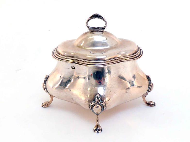 A silver tea caddy of oval quatrefoil form, marks indistinct, Chester, 1915, the four claw feet
