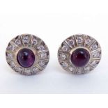 A pair of 1950s ruby and diamond ear clips, each with a central oval cabochon, 7.5 x 6.5mm, in a